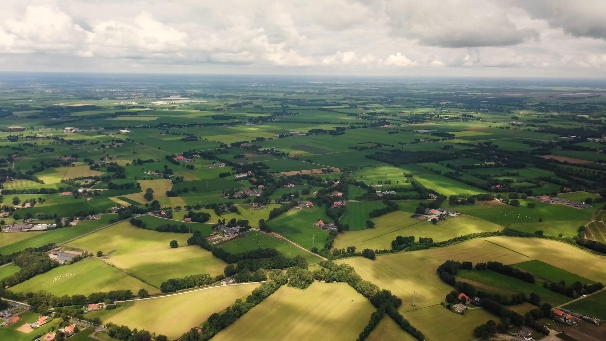 Het Overijsselse landschap vanuit de lucht, met akkers, houtwallen en boerderijen